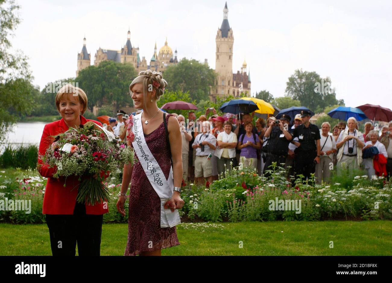 German Chancellor Angela Merkel poses with 'flower fairy' Victoria Salomon  (R) during her visit at the Bundesgartenschau 2009 (BUGA 2009) federal  horticultural show in Schwerin July 15, 2009. REUTERS/Christian Charisius  (GERMANY POLITICS
