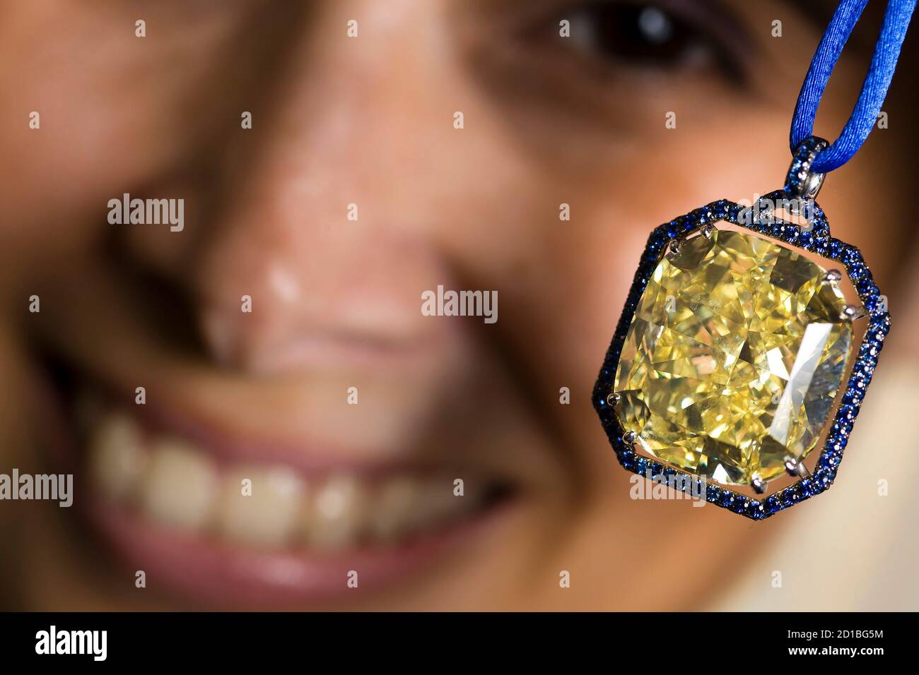 A model displays a 65.2 carat fancy intense yellow cushioned shaped diamond  pendant during an auction preview at Christie's in Geneva November 13,  2009. The pendant is estimated to fetch between 850.000