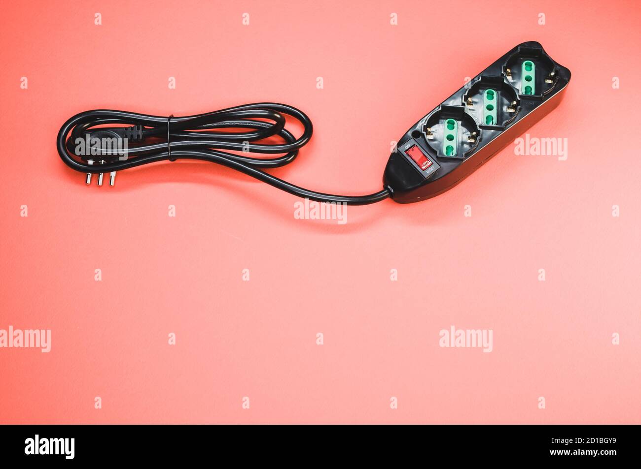 Black surge protector on a light red background Stock Photo Alamy
