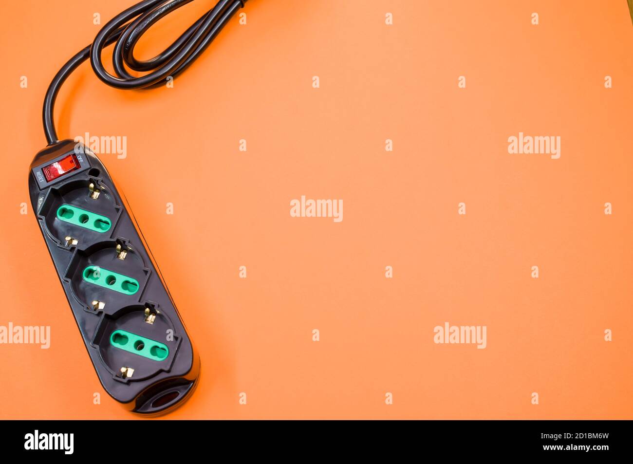 Black surge protector on an orange background Stock Photo Alamy
