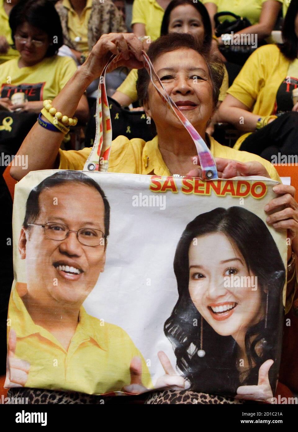 A supporter shows her handbag made from an election campaign poster of Philippine Senator Benigno 'NoyNoy' Aquino III  who will be proclaimed winner of the presidential election shortly at the House of Representatives in Quezon City, Metro Manila June 9, 2010. At right, is Benigno's sister, Philippines actress Kris Aquino.    REUTERS/Erik de Castro  (PHILIPPINES - Tags: POLITICS ELECTIONS SOCIETY) Stock Photo