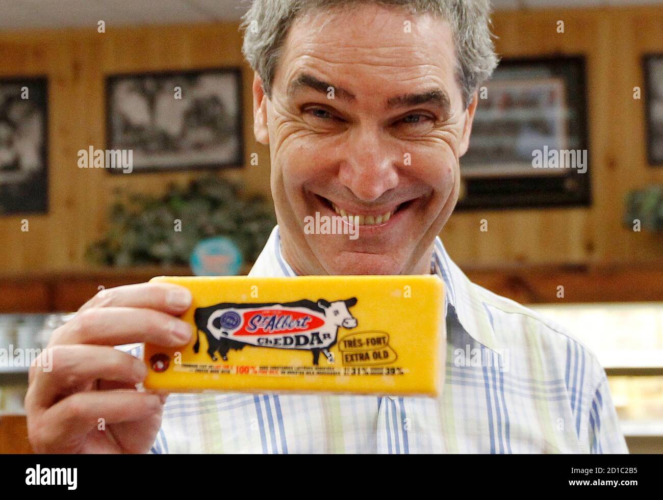 Liberal leader Michael Ignatieff holds up cheese for photographers while visiting the St-Albert Cheese Co-operative in St-Albert, Ontario July 13, 2010.       REUTERS/Chris Wattie       (CANADA - Tags: POLITICS) Stock Photo
