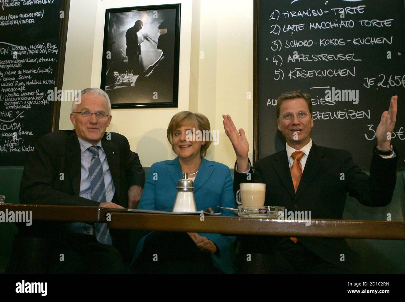 North-Rhine Westphalia's Prime Minister Ruettgers Conservative challenger Merkel and FDP leader Westerwelle pose for photographers in Bonn.  North-Rhine Westphalia's Prime Minister Juergen Ruettgers (L) Conservative challenger Angela Merkel (C) leader of Germany's Christian Democratic Union (CDU) and Guido Westerwelle, leader of the German liberal Free Democratic Party (FDP) pose for photographers in a restaurant in the western German city of Bonn September 17, 2005. German Chancellor Gerhard Schroeder and his rival Angela Merkel launched a final drive on election eve on Saturday to win over u Stock Photo