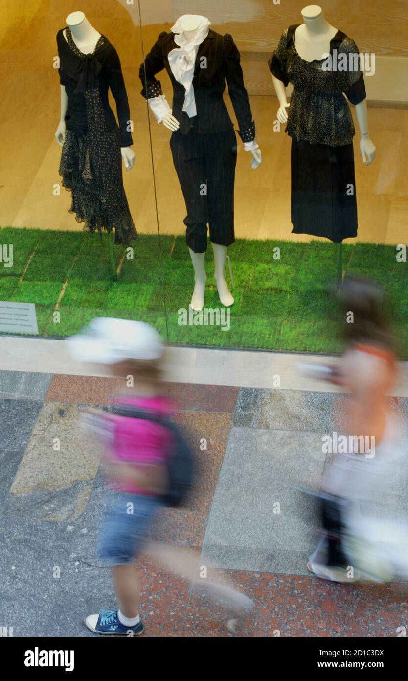 Pedestrians walk past a boutique in the upmarket State Department Store  (GUM) in Moscow's Red Square June 27, 2006. Giorgio Armani, Ferrari,  Bentley: the brand names along Moscow's central thoroughfare look like