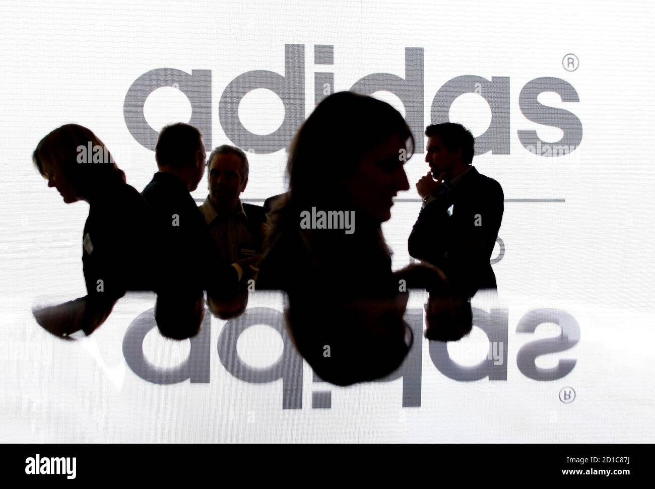 Shareholders' of Adidas Group are silhouetted in front of the company logo  before the annual shareholder meeting in Fuerth near Nuremberg May 8, 2008.  REUTERS/Michaela Rehle (GERMANY Stock Photo - Alamy