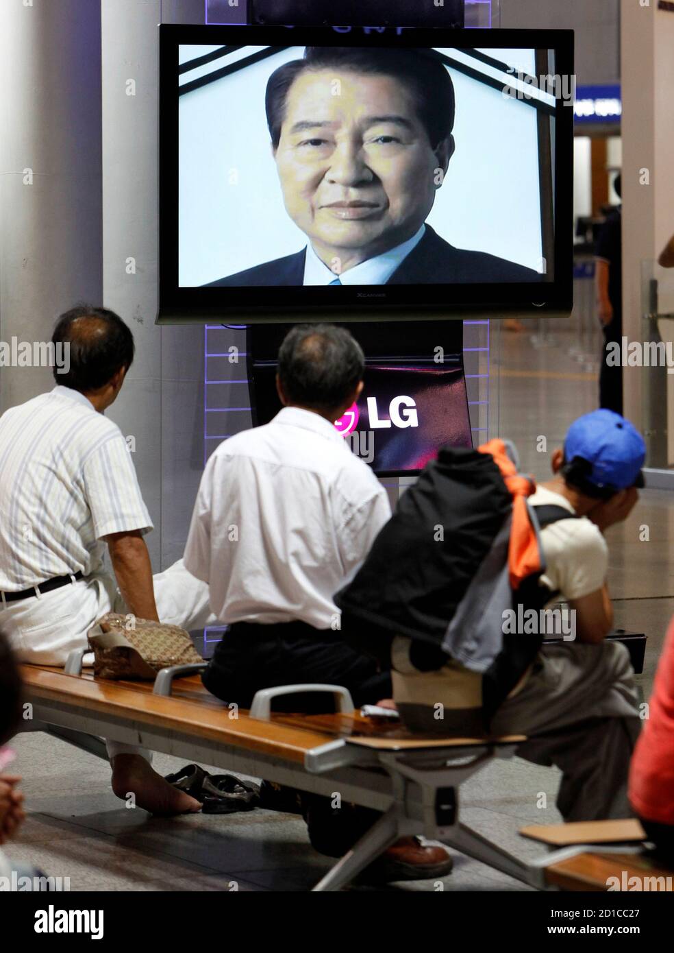 People watch the news on former South Korean President Kim Dae-jung's death at the Seoul railway station August 18, 2009. Former South Korean President Kim, a towering figure in South Korea's struggle for democracy who won the 2000 Nobel Peace Prize for seeking rapprochement with the communist North, died on Tuesday at the age of 85. An official at a Seoul hospital treating Kim for pneumonia confirmed the death.    REUTERS/Jo Yong-Hak (SOUTH KOREA POLITICS OBITUARY) Stock Photo
