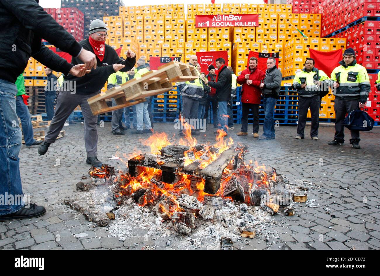 Workers Gather Near A Fire As Racks Of Beer Bottles Block The Entrances Of Anheuser Busch Inbev S Plant In Jupille Near Liege January 15 2010 Anheuser Busch Inbev The World S Largest Brewer Said On