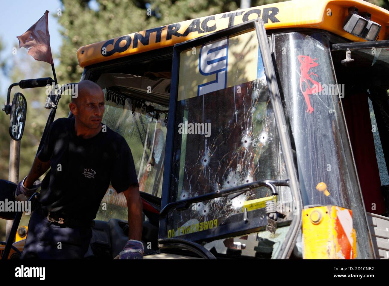 An Israeli worker stands on a bulldozer at the scene of an attack in Jerusalem July 22, 2008. A bulldozer went on a rampage in Jewish west Jerusalem on Tuesday, in the second such attack this month, and rammed into cars before the bulldozer's driver was shot dead, police said.  REUTERS/Baz Ratner (JERUSALEM) Stock Photo
