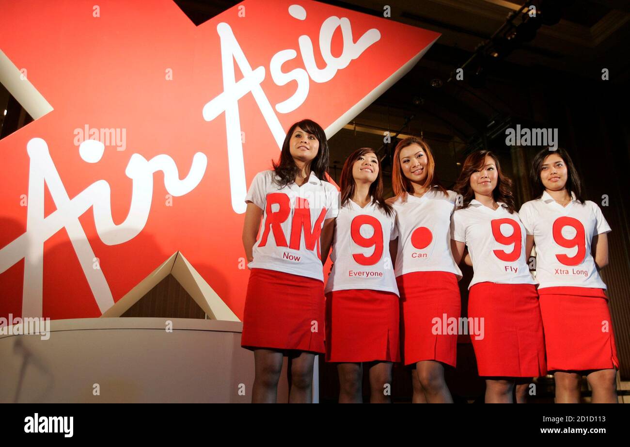 Malaysian budget carrier AirAsia stewardesses pose during the unveiling of plans for a low-cost longhaul service in Kuala Lumpur January 5, 2007. AirAsia Bhd on Friday announced plans to double its Airbus A320 fleet, with its major owners also unveiling plans for a long-haul low-cost airline that would help it fly beyond Aisa.    REUTERS/Zainal Abd Halim (MALAYSIA) Stock Photo