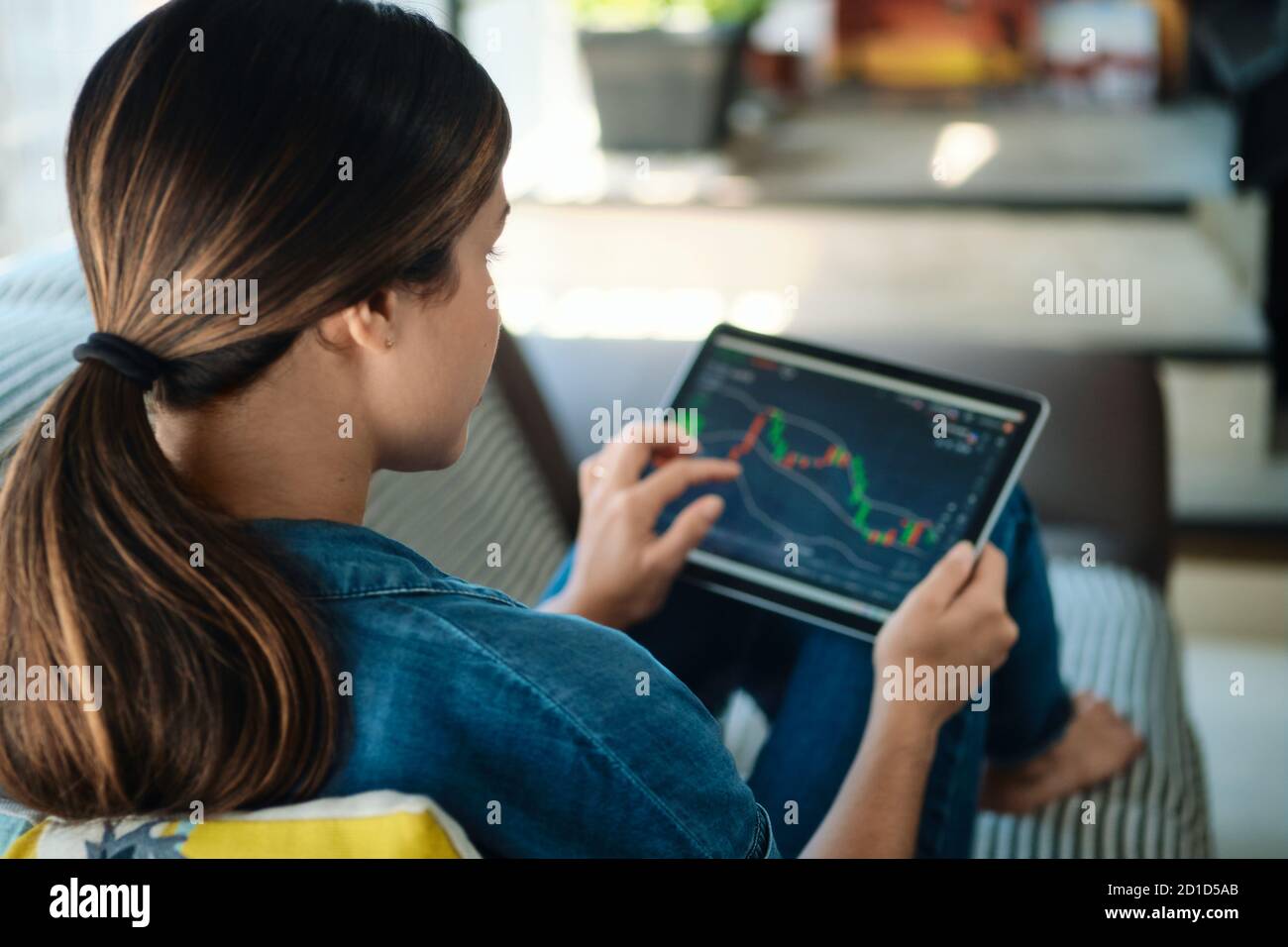 Woman Trading Online Using Tablet Computer On Sofa Stock Photo