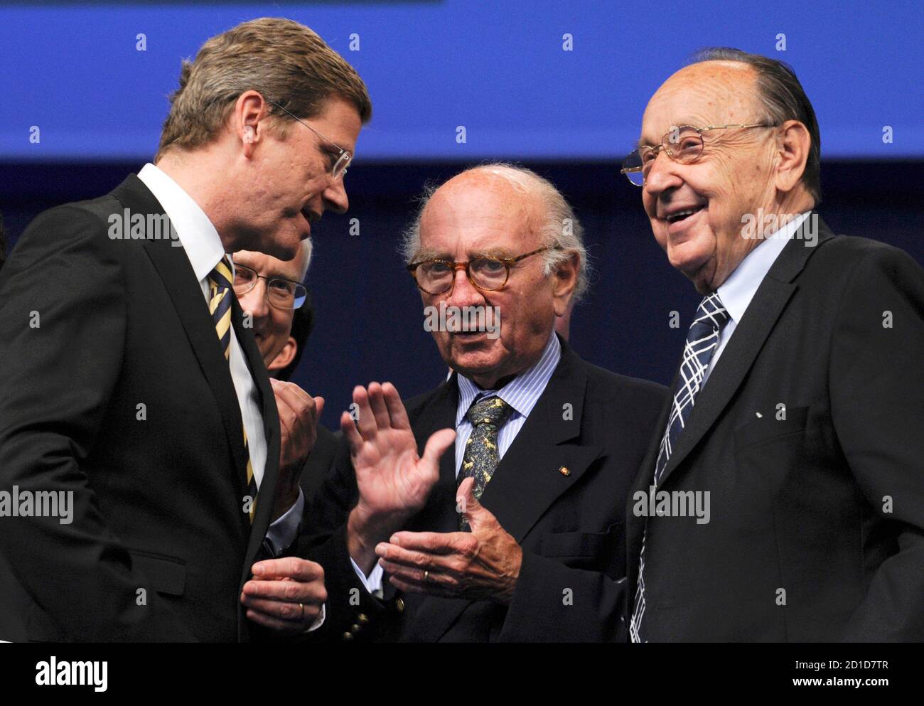 Guido Westerwelle (L), party leader of Germany's liberal Free Democratic Party (FDP) speaks to former FDP leaders Otto Graf Lambsdorff (C) and Hans-Dietrich Genscher following his key-note speech at a three-day FDP party congress in Hanover May 15, 2009.   REUTERS/Wolfgang Rattay    (GERMANY) Stock Photo