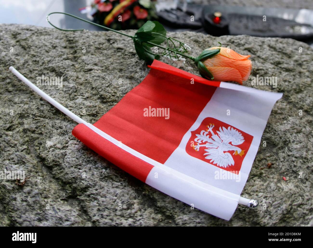 A rose and a Polish flag is placed on the grave of Major Henryk Sucharski who defended Poland during the first days of the World War II at Westerplatte, outside of Gdansk August 31, 2009. European leaders will commemorate on Tuesday the 70th anniversary of the outbreak of World War Two at ceremonies in Poland already clouded by disputes over historic responsibility that pit Russia against the West. Russian Prime Minister Vladimir Putin's speech in the Polish Baltic port of Gdansk will be keenly scrutinised by Poles, Balts and others irked by what they see as Moscow's attempts to whitewash Sovi Stock Photo