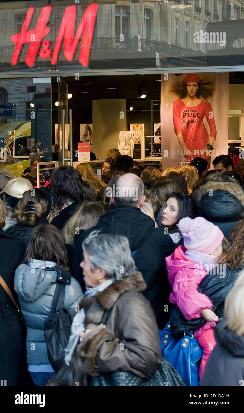 People rush through the front door of H&M store during the launch of a  collection by French fashion designer Sonia Rykiel for H&M in Paris  February 20, 2010. REUTERS/Gonzalo Fuentes (FRANCE -