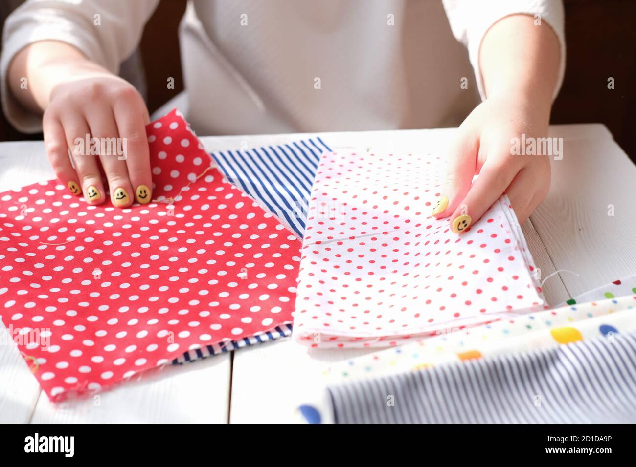 Female fashion designer holding fabric textile red and blue shades at workplace, dressmaker or tailor making choice, close up view Stock Photo
