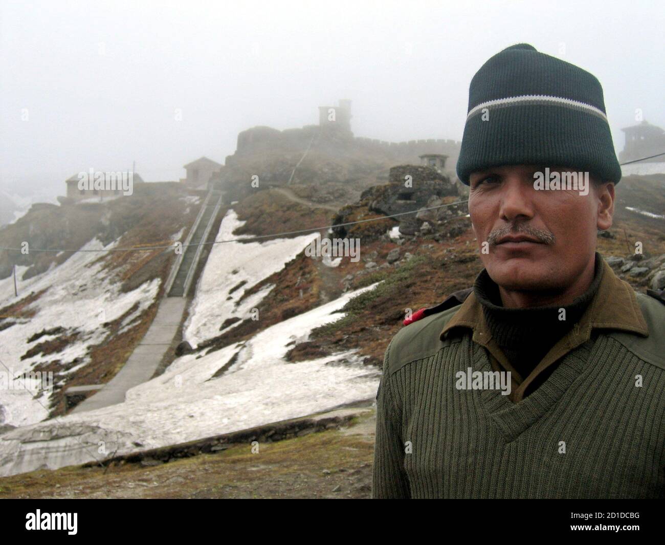 An Indian soldier stands at the 4,310 metre high Nathu-la pass on the country's north-eastern border with China in this May 29, 2006 file photo. Just a few yards away bulldozers on both sides of the frontline are building not fortifications but a road, to connect India and China and reopen a historic trade route. New Delhi and Beijing plan to reopen the Nathu-la pass in June after more than 40 years, a potent symbol of rapprochement between Asian giants who fought a Himalayan war in 1962. Picture taken May 29, 2006.  To match feature INDIA CHINA TRADE.  REUTERS/Simon Denyer  (INDIA) Stock Photo