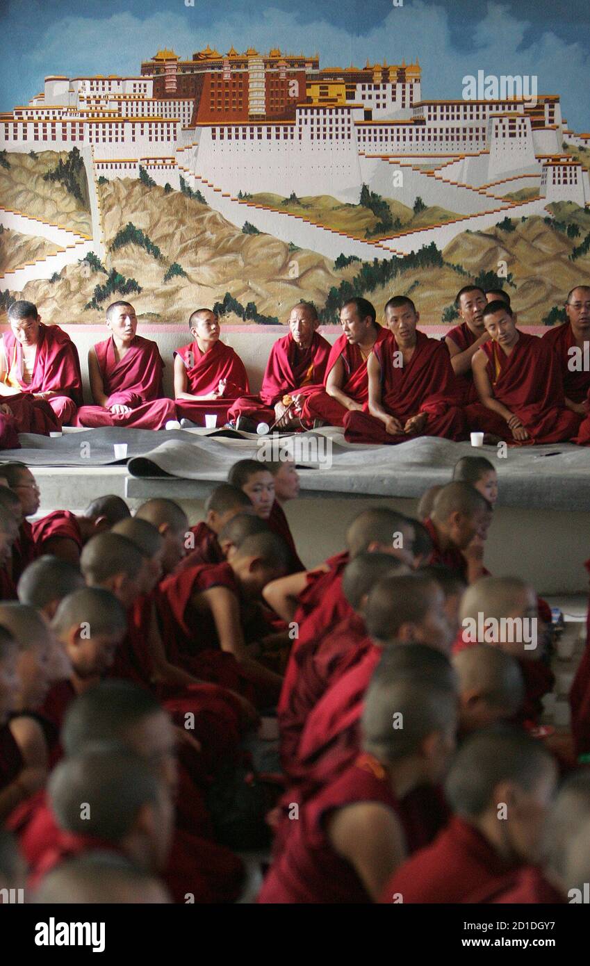 Tibetan monks and nuns take part in a prayer at Baudha in the Nepali capital Kathmandu March 18, 2008. The prayers are to show solidarity for the Tibetan people and for those killed during protests in Lhasa. The painting in the background is that of the Potala Palace in Lhasa. REUTERS/Gopal Chitrakar (NEPAL) Stock Photo