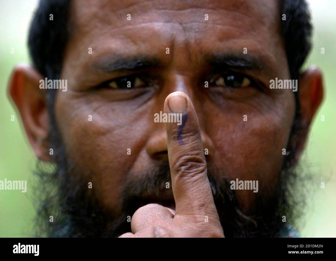 A Muslim man shows his ink-marked finger after casting his ballot at a polling station in Tiamari village, about 280 km (174 miles) west from Guwahati, the major city of India's northeastern state of Assam April 23, 2009. Tens of millions of Indians from insurgency-hit states to the IT hub of Bangalore began voting on Thursday in the second round of a month-long election that could throw up a weak coalition amid an economic slump. REUTERS/Rupak De Chowdhuri (INDIA POLITICS ELECTIONS) Stock Photo
