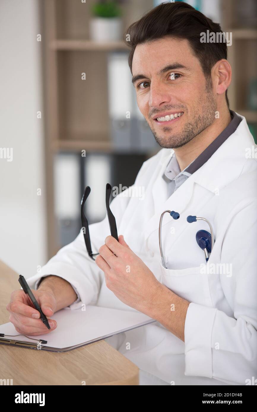 doctor man filling up medical form at clipboard Stock Photo