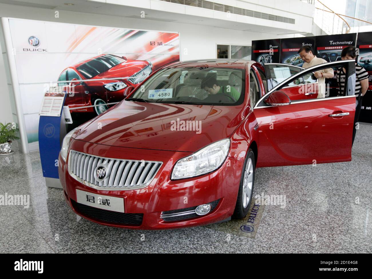 Customers look at a Buick Regal car at a General Motors auto dealership in Shanghai May 29, 2009. GM is facing imminent bankruptcy in the United States after bondholders rejected a debt-for-equity swap, a key part of the restructuring plan it needs to complete before a June 1 deadline imposed by the administration of President Barack Obama. Its China division, primarily two ventures with SAIC Motor, is profitable and self-sufficient, and able to fund its own daily operations and expansion, executives say. REUTERS/Aly Song (CHINA TRANSPORT BUSINESS) Stock Photo