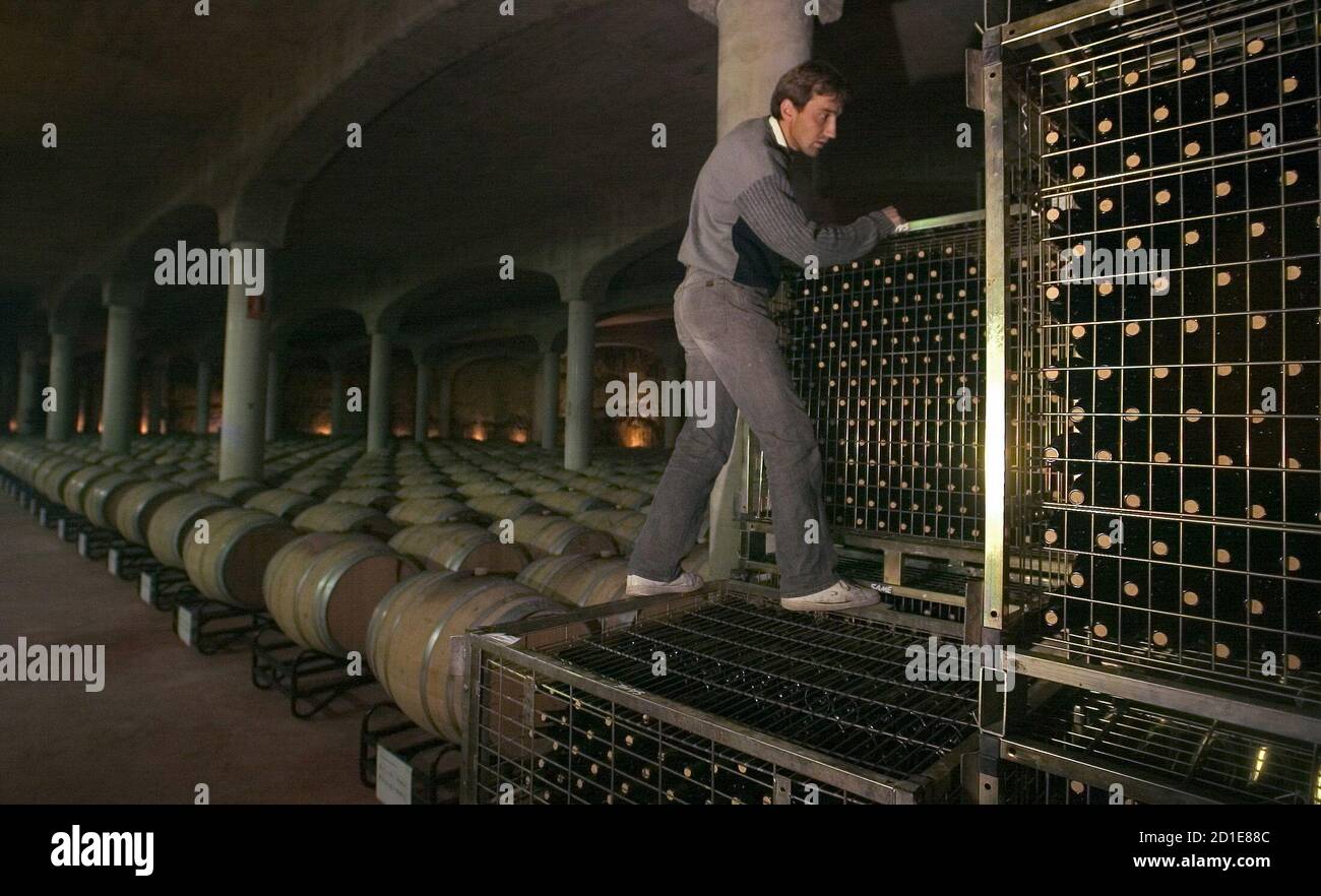 -PHOTO TAKEN 12OCT05- An oenologist checks stored bottles at Castillo de Mendoza wine cellar in San Vicente de la Sonsierra, northern Spain, October 12, 2005. In the geographical border between the craggy northern and the flat central Spain, straddling the river Ebro, Rioja region enjoys a mild and temperate climate and its wines are considered the best of the peninsula. Last year around 120 million kilos (264 million pounds) were collected in La Rioja, this means 40 % of the total wine of Spain which is produced in around 1400 wineries registered at the Rioja Designation of Origin Organisatio Stock Photo