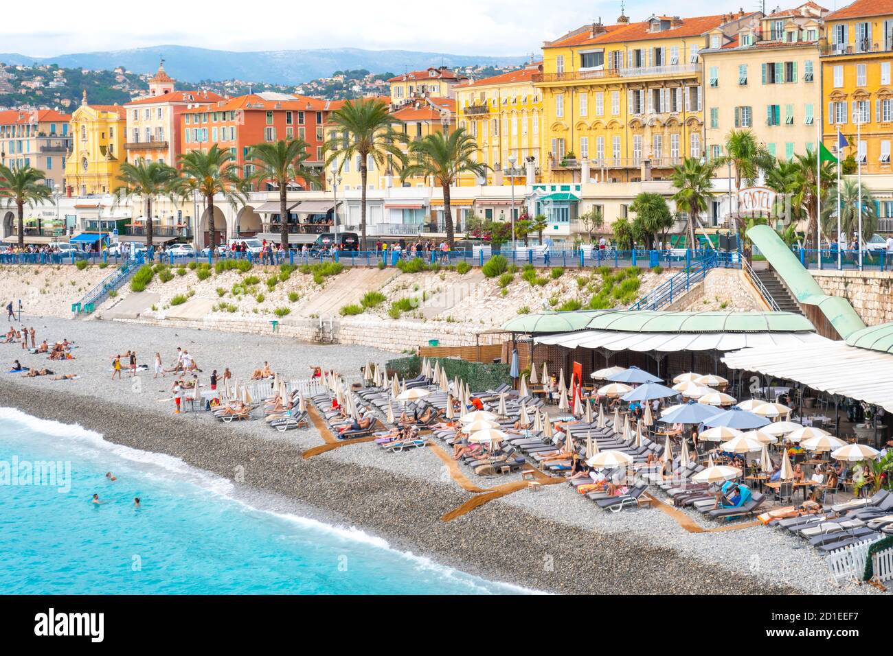 Tourists enjoy the Castel Plage private beach club and restaurant on the shores of the Bay of Angels on the Riviera in Nice, France Stock Photo