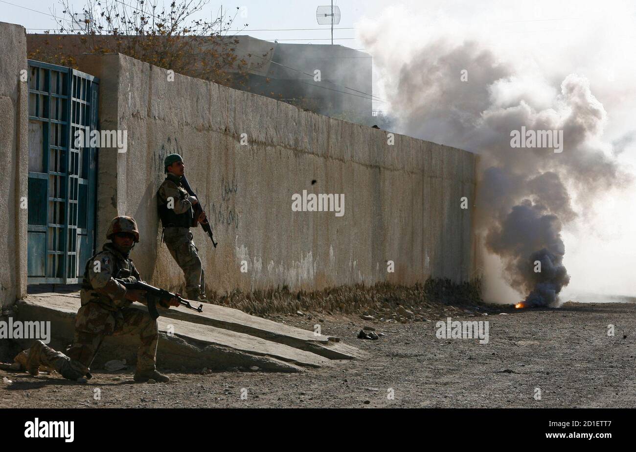 Iraqi soldiers take up position after throwing a smoke grenade during a patrol with troops from the U.S. Army's 101st Airborne Division in Baiji December 27, 2007. REUTERS/Bob Strong (IRAQ) Stock Photo