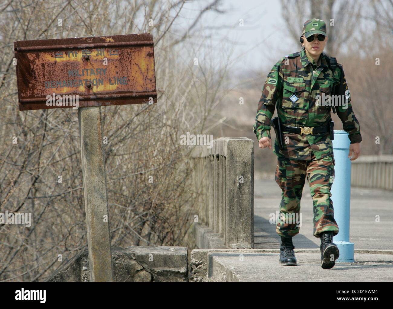 A South Korean soldier walks past a sign of the military demarcation line  beside the bridge of no return at the truce village of Panmunjom in the  demilitarized zone in Paju, 42