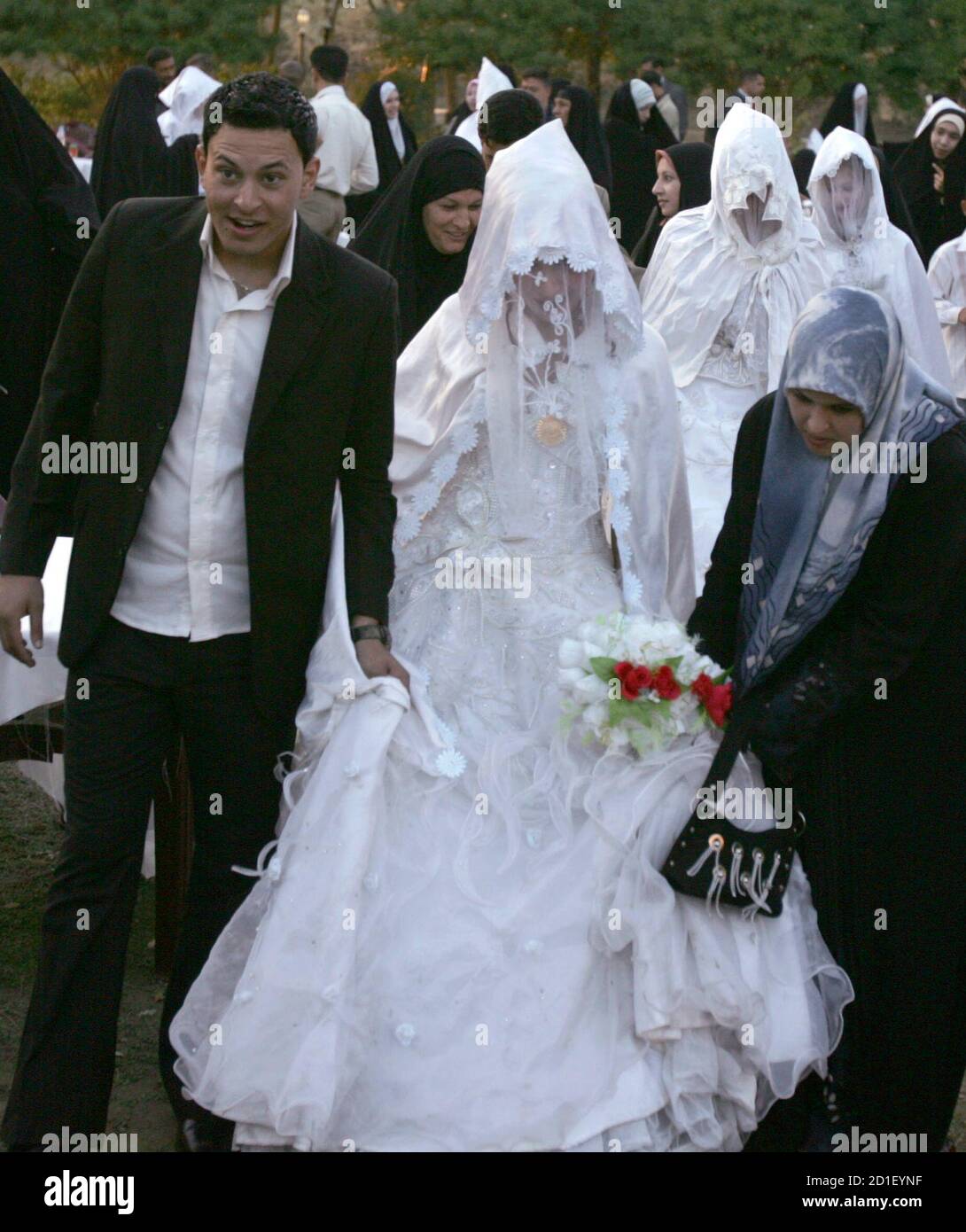 Iraqi brides and grooms arrive to attend a mass wedding ceremony involving 200 couples organized by the local government in Hilla, 100 km (62 miles) south of Baghdad December 1, 2008. Picture taken December 1, 2008. REUTERS/Mushtaq Muhammed (IRAQ) Stock Photo