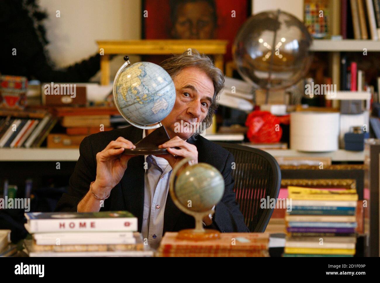 British designer Paul Smith poses for a photo at his desk in his office in  central London February 17, 2009. As the world falls deeper into a  recession, British fashion powerhouse Sir