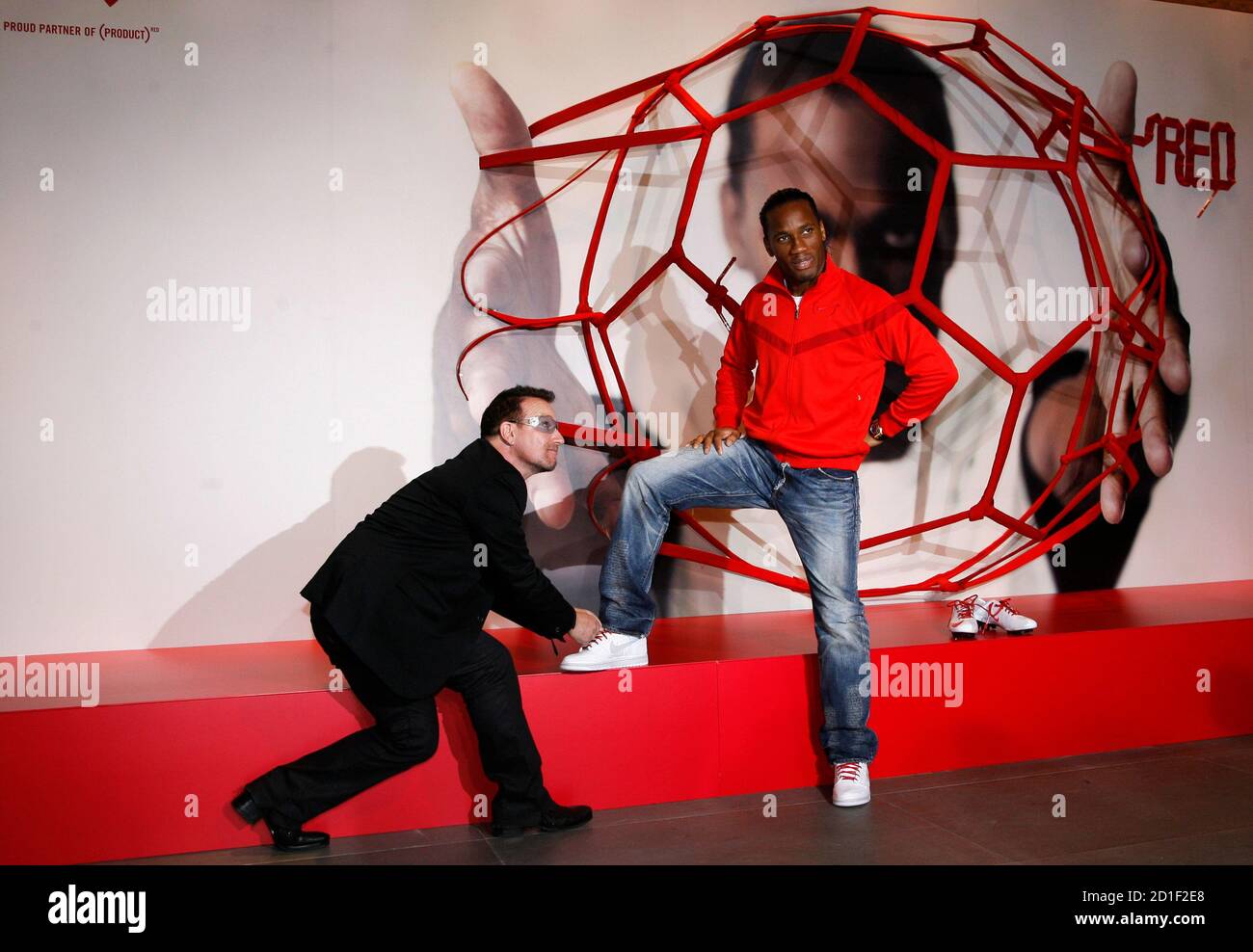 Singer Bono (L) and footballer Didier Drogba pose for photographers after a  news conference to launch a partnership between Nike and (RED) in London,  November 30, 2009. The two groups will unite