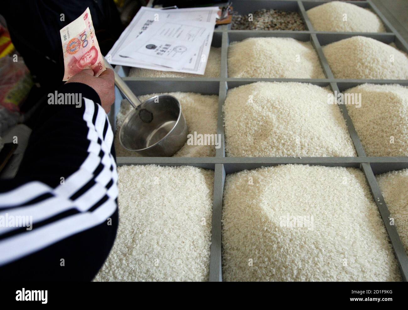 A customer pays for rice at a market in Beijing April 3, 2008. World rice production is set to increase by 1.8 percent this year as government incentives and high prices spur output in Asia and Africa, the United Nations Food and Agriculture Organisation (FAO) said on Wednesday. REUTERS/Jason Lee (CHINA) Stock Photo