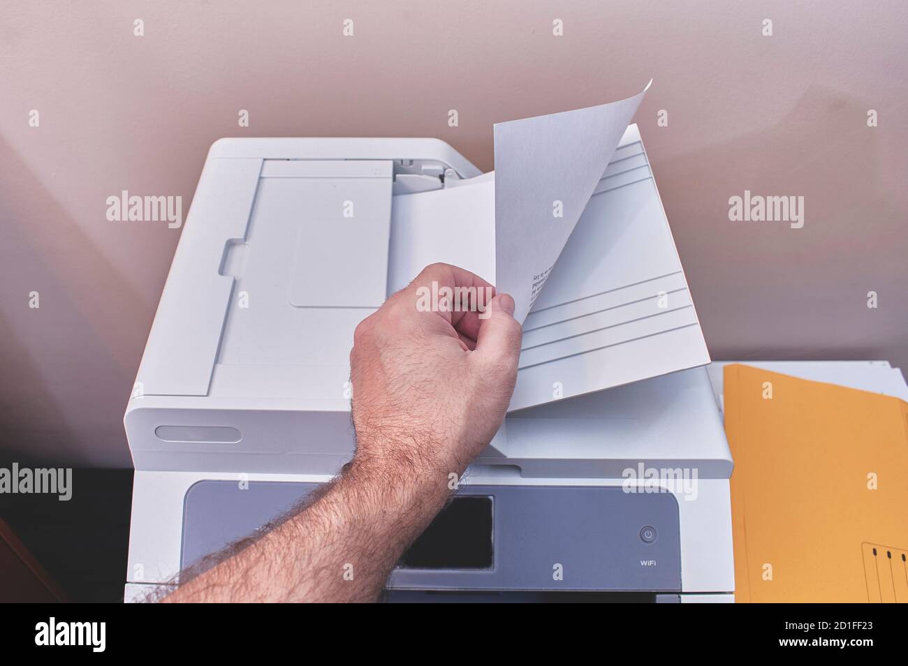 A person is making photocopies or printing documents in an office Stock Photo