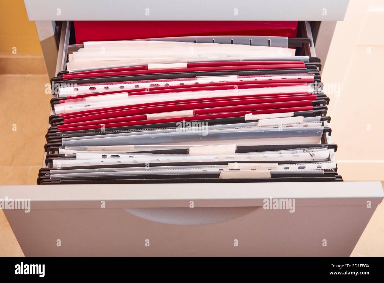 Documents organized in a metal office drawer filing cabinet full of subfolders and folders in an office Stock Photo