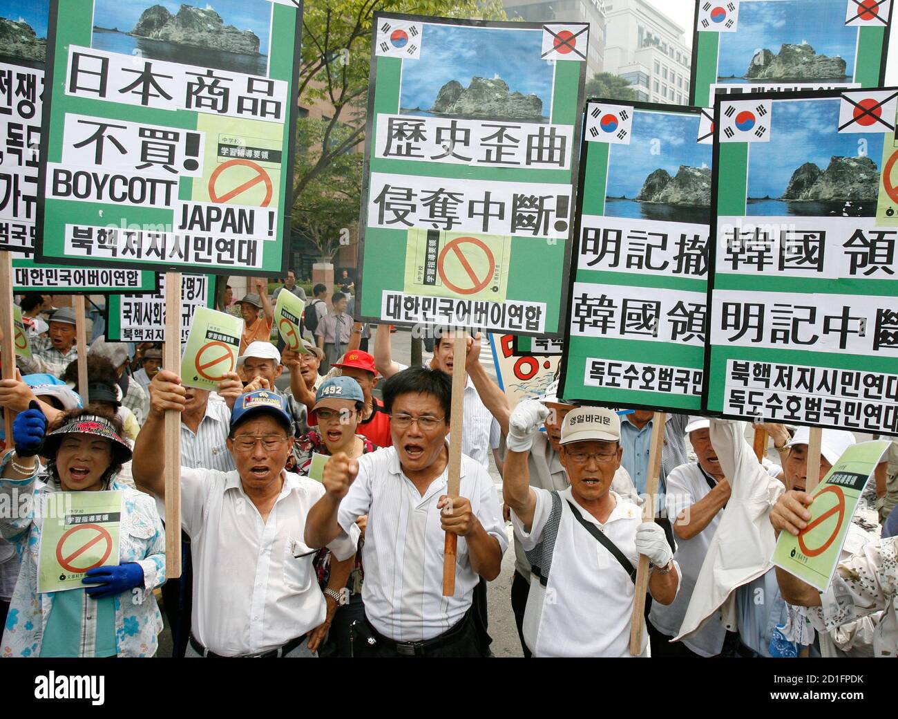 Protesters chant slogans at a demonstration against Japan's sovereignty claim over a group of desolate volcanic islets Seoul and Pyongyang call Dokdo and Tokyo calls Takeshima, in front of Japanese embassy in Seoul July 15, 2008. South Korea's coastguard said on Tuesday it had stepped up patrols near the islands, a day after Seoul recalled its ambassador in anger at new Japanese claims to the rocky outcrops. On Monday, Tokyo said it had told Seoul that it would refer in a middle school teaching guide to the islands as Japanese territory. A sign (2nd L, front) reads,"Stop distortion of history Stock Photo