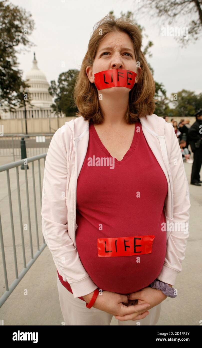 A pregnant pro-life demonstrator stands before the Supreme Court in Washington October 6, 2008. Amid a presidential race that may decide its future direction, the Supreme Court began a new term today with cases about tobacco company lawsuits, protecting whales from Navy sonar and a government crackdown on dirty words on television. REUTERS/Kevin Lamarque   (UNITED STATES) Stock Photo