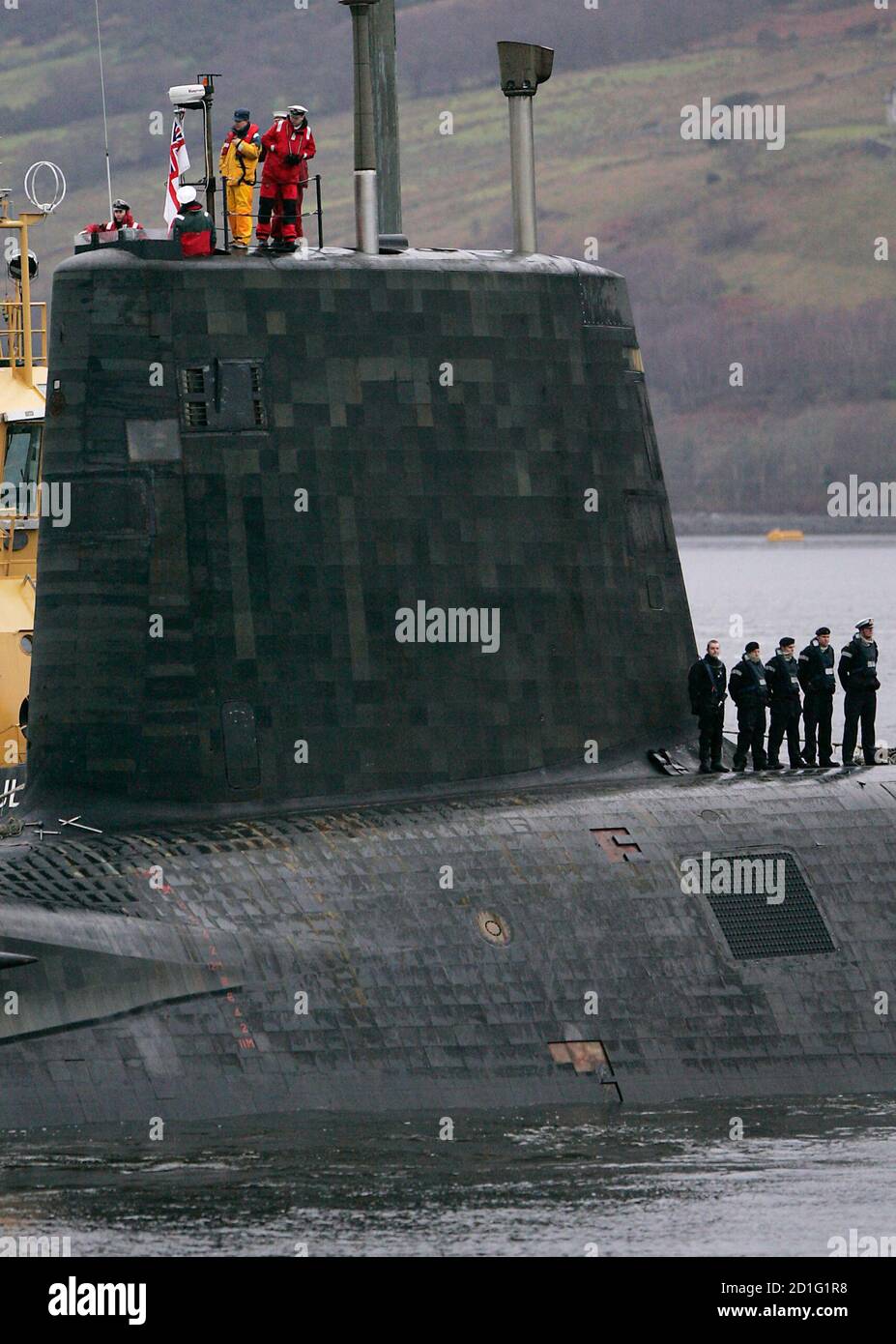 Crew from HMS Vengeance, a British Royal Navy Vanguard class Trident  Ballistic Missile Submarine, look out from the conning tower as they return  along the Clyde river to the Faslane naval base