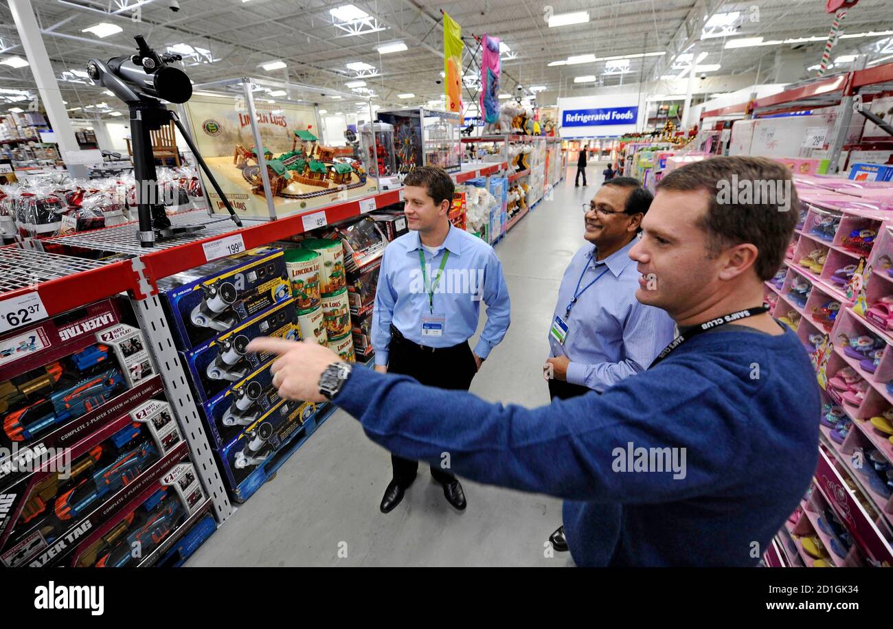 Sam's Club Chief Executive Doug McMillon (R) talks with Vice President and  Regional General Manager John Furner (L) and New York City Markets Manager  Mohamed Khan (C) in the toy section of