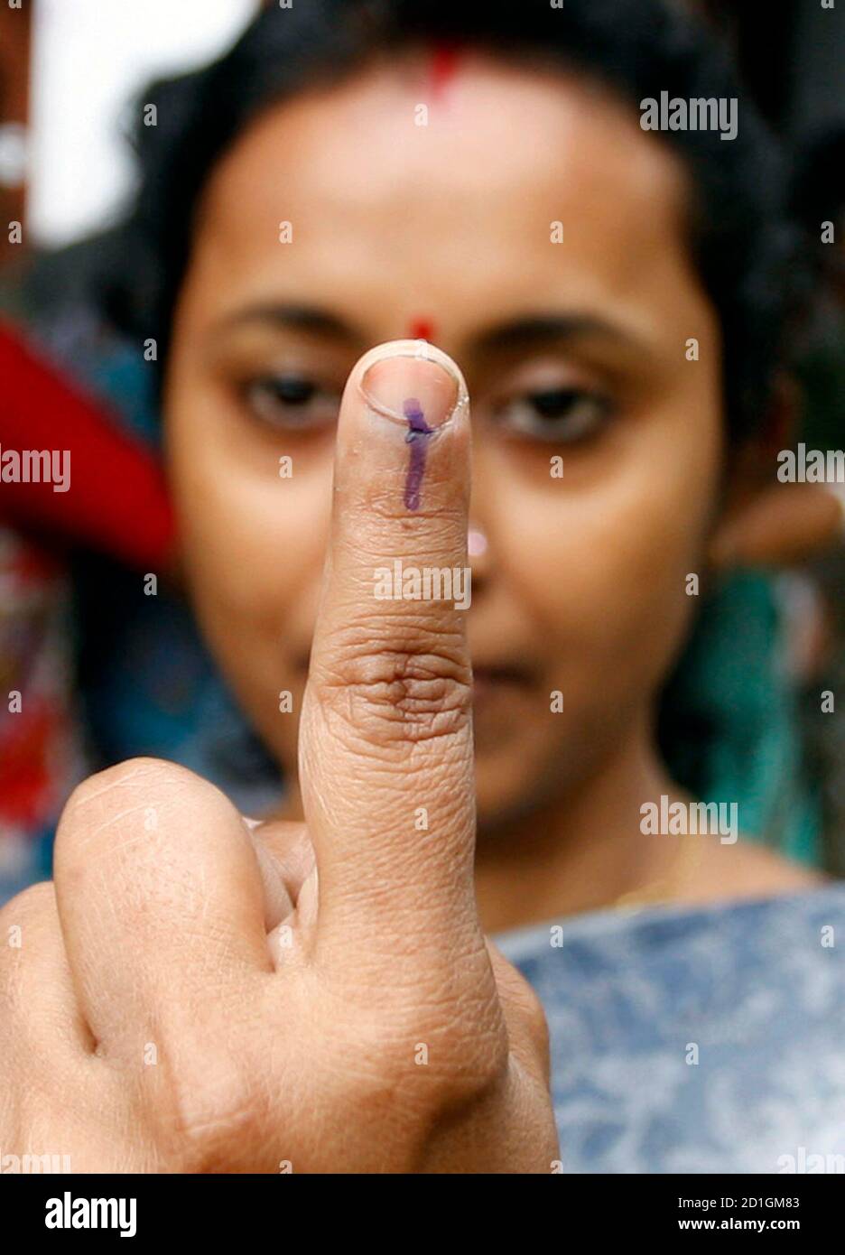 A voter shows the indelible ink mark on her finger after casting her ballot at a polling booth in the eastern Indian city of Siliguri April 30, 2009. Millions of Indians began voting in the third round of a general election on Thursday in several states seen as key to the Hindu-nationalist Bharatiya Janata Party's bid to win power from the Congress-led ruling coalition. REUTERS/Rupak De Chowdhuri (INDIA ELECTIONS POLITICS) Stock Photo