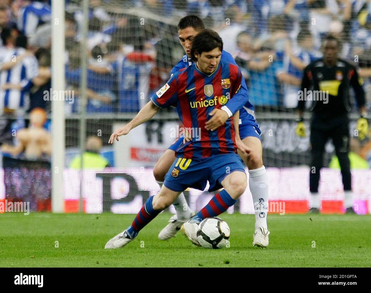 Barcelona's Lionel Messi (front) is challenged by RCD Espanyol's Victor Ruiz  during their Spanish first division soccer match at Cornella Prat stadium  in Barcelona April 17, 2010. REUTERS/Gustau Nacarino (SPAIN - Tags: