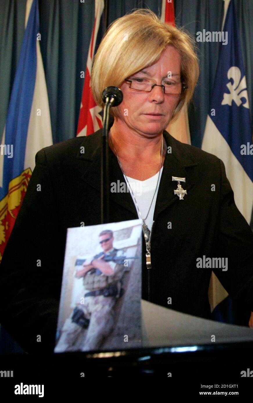Laurie Dinning prepares to leave a news conference as a photograph of her son, Corporal Matthew Dinning, rests on the podium, on Parliament Hill in Ottawa May 30, 2007. Corporal Dinning was killed with three other Canadian soldiers in a roadside explosion in Afghanistan in April 2006. Canada, trying to tackle another controversy involving its military mission to Afghanistan, ordered a probe on Wednesday into reports that Ottawa had broken promises to pay the funeral costs of those killed in action.  REUTERS/Chris Wattie (CANADA) Stock Photo