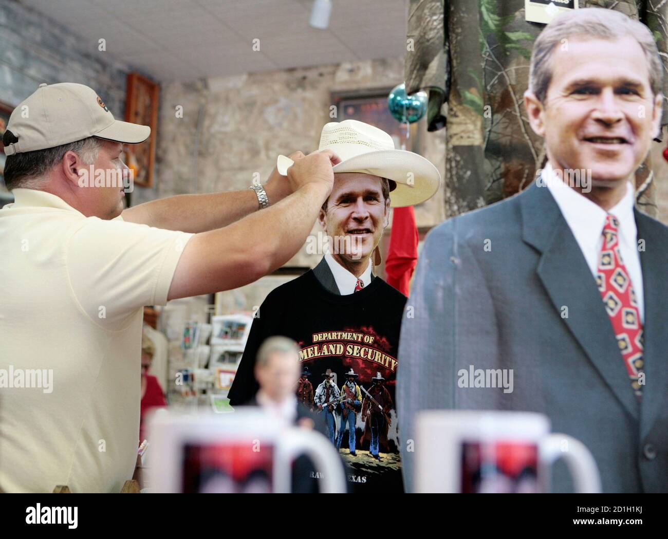 Dennis Mann L Adjusts A Cowboy Hat On A Cutout Of U S President George W Bush In The Yellow Rose Tourist Shop In Crawford Texas May 10 2008 U S President George W