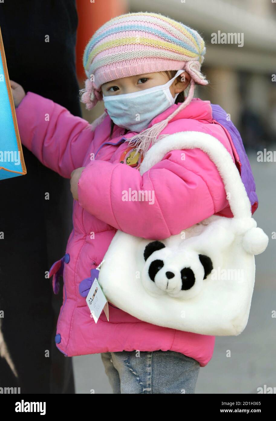 A child wearing a coat looks at the camera in Beijing December 4, 2008. A Siberian cold front swept China on Thursday, with temperatures in the capital plunging below freezing and thousands stranded on snowbound expressways in the remote far northwest. REUTERS/Jason Lee (CHINA) Stock Photo