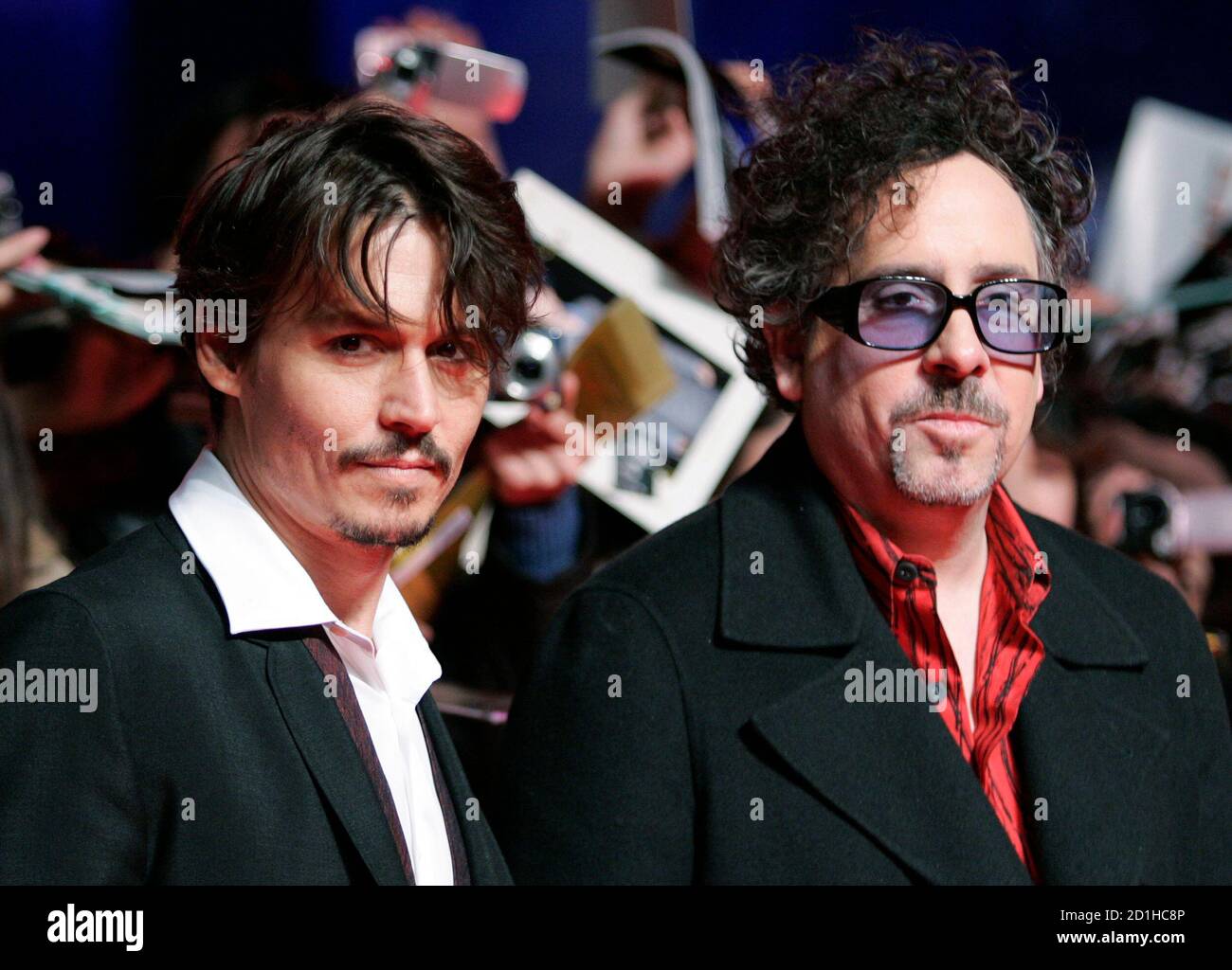 U.S. actor Johnny Depp (L) and director Tim Burton pose for photographers  as fans wave and take photos at a red carpet event in Tokyo January 8,  2008. Depp and Burton are