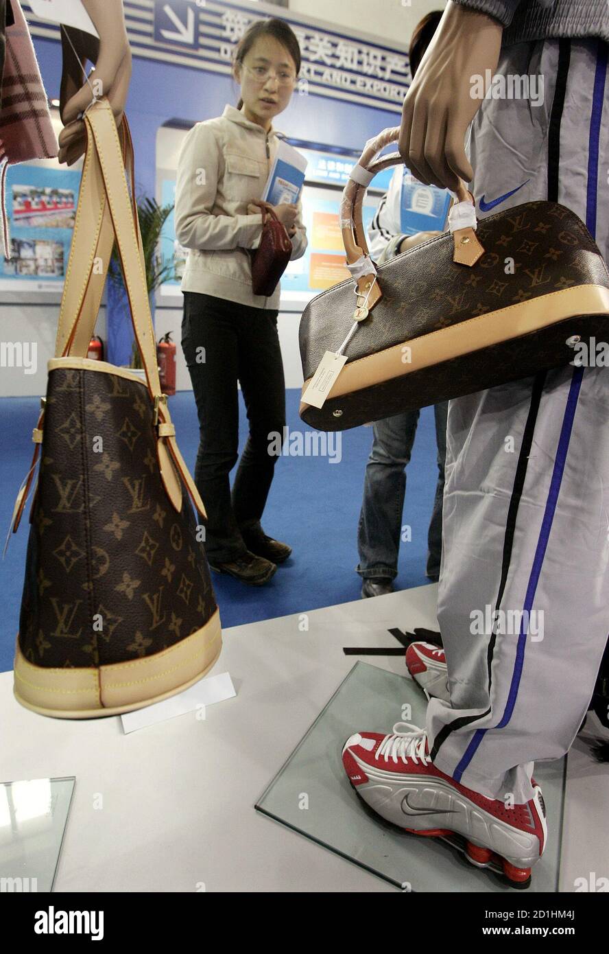 A visitor looks at fake designer bags displayed at an exhibition of China's  achievements in Intellectual Property Protection in Beijing April 17, 2006.  Washington has repeatedly complained that unauthorised Chinese copying of