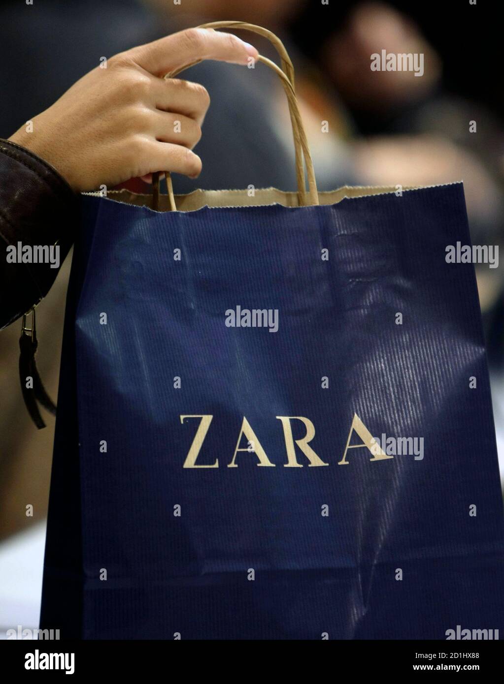 A customer takes a bag inside a Zara store in central Madrid October 20,  2008. Every piece of Zara clothing sold in nearly 1,500 stores worldwide  passes through this cavernous distribution centre