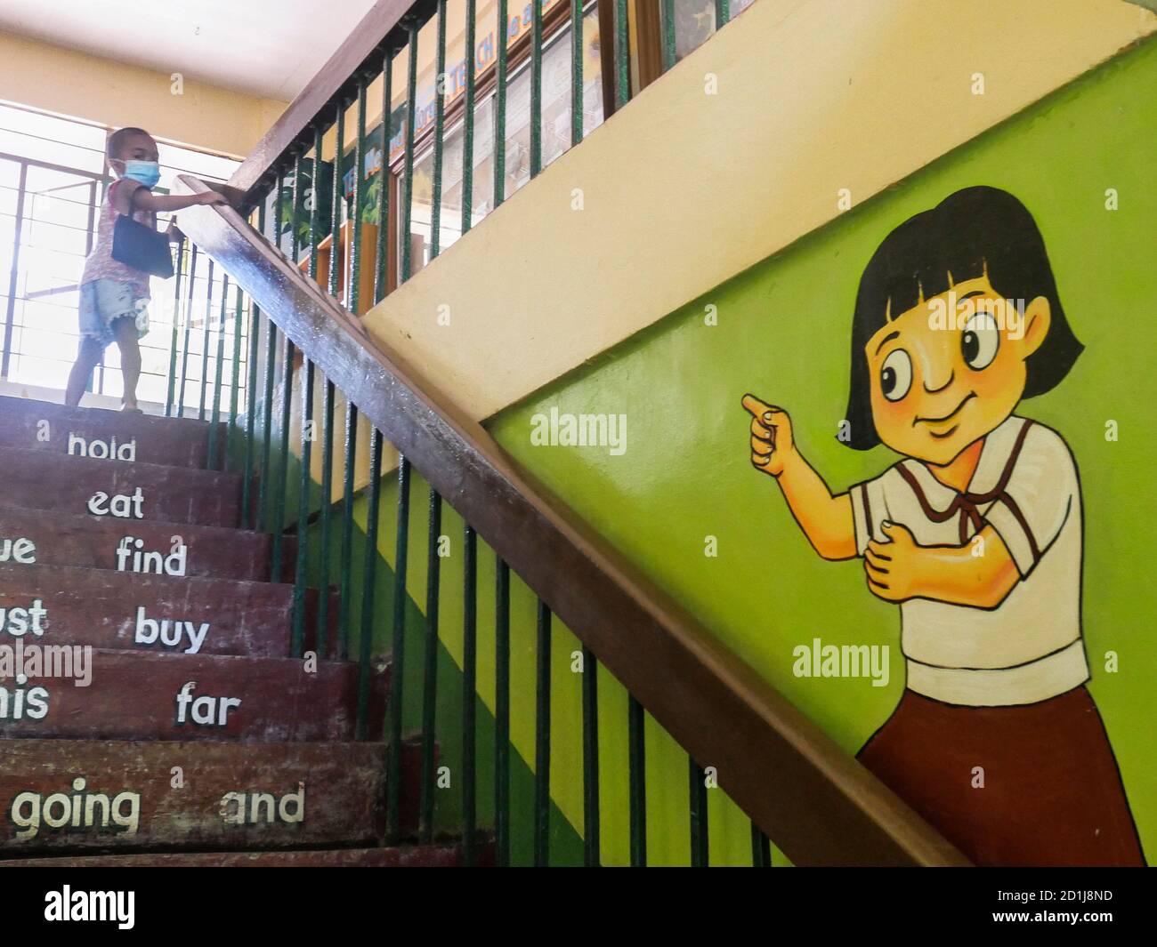 Talon 5, Las Pinas City, Philippines - 10/05/2020: A child climbs the stairs inside the empty Moonwalk Elementary School in Talon 5, Las Pinas City. Today is the opening of classes as scheduled by the Department of Education but due to covid-19 paandemic, students are not required to physically report to school but to study and learn instead via Subject Modules handouts prepared and given by subject teachers. Prior to the opening, the said school had conducted a survey asking Parents if they prefer Online Learning or Modular Learning, only (10%) ten percent favored Online learning due to inh Stock Photo