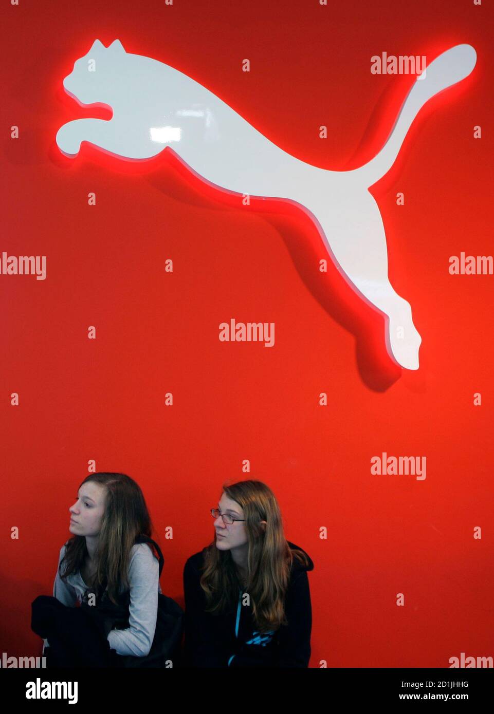 People rest under a Puma sign at the factory outlet store in Herzogenaurach  near Nuremberg April 10, 2007. French retailer PPR on Tuesday made a 5.3  billion euro ($7.07 billion) bid to