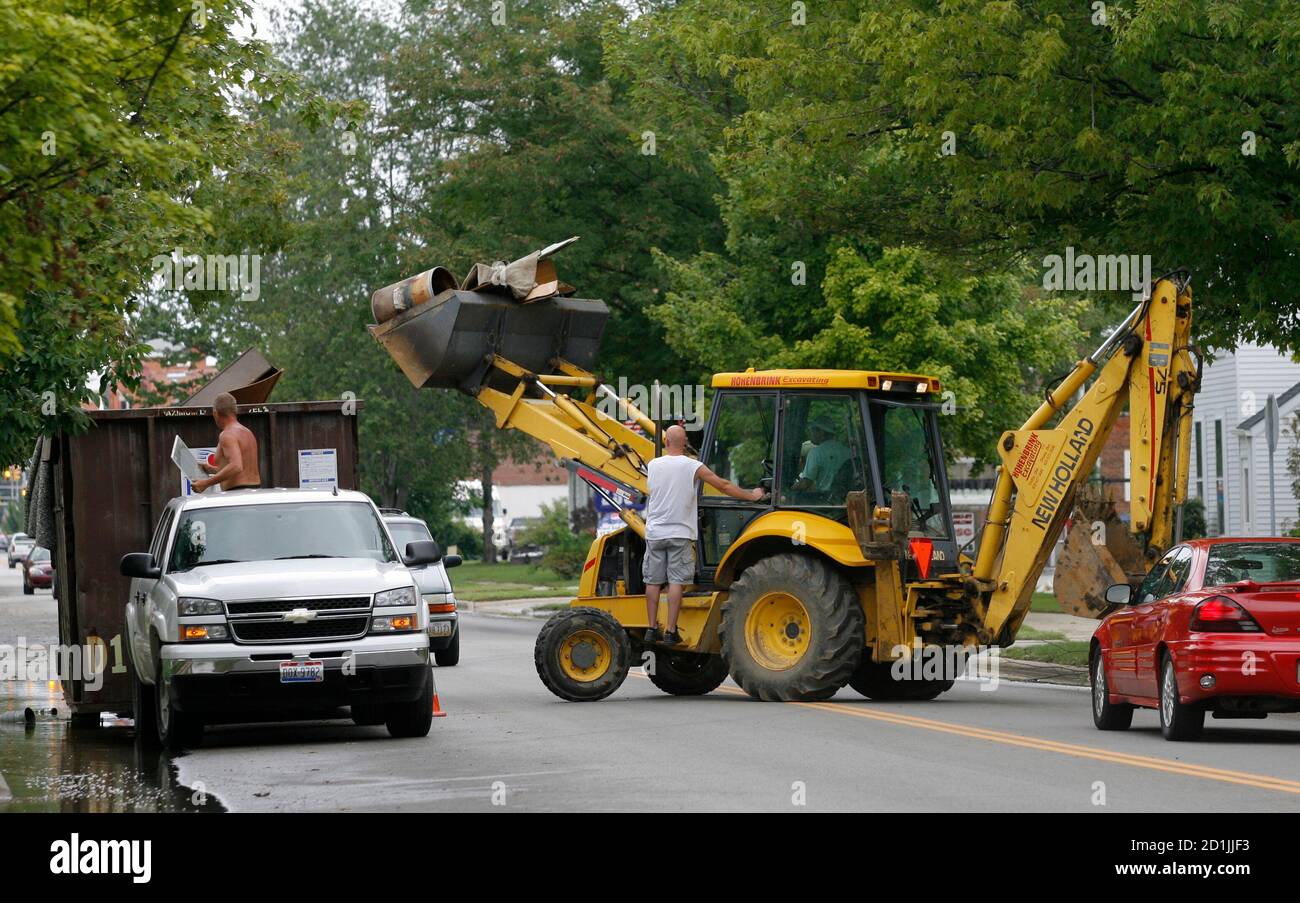 Residents of Ottawa throw away trash into a community dumpster while