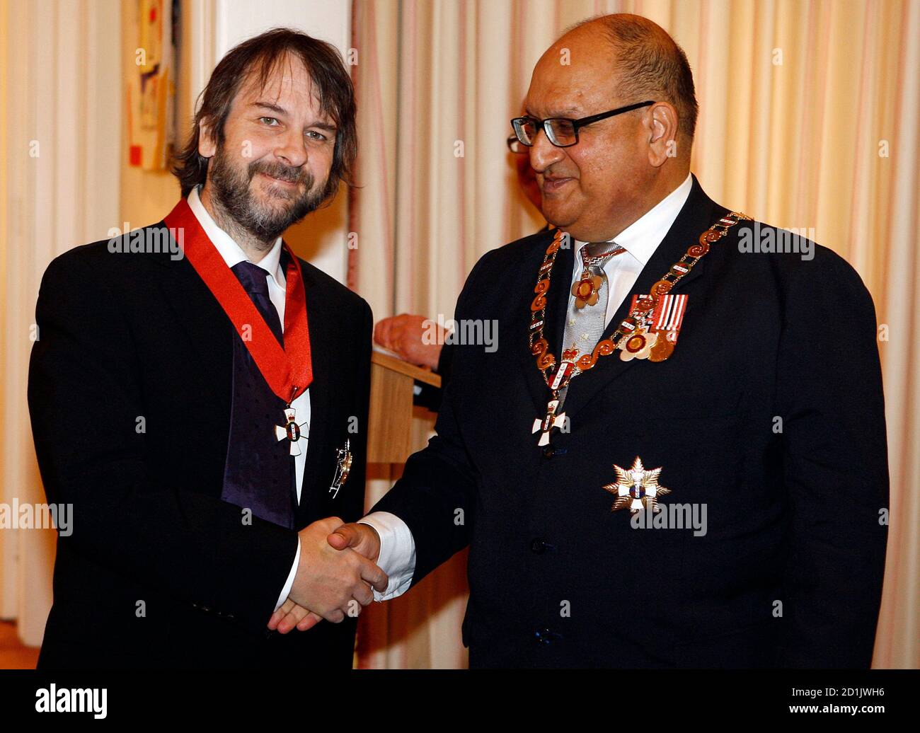 Director Peter Jackson (L) of New Zealand shakes hands with New Zealand's Governor-General Anand Satyanand after being knighted by Satyanand at Premier House in Wellington April 28, 2010. Jackson who directed the 'Lord Of The Rings' trilogy, received the Knight Companion of the New Zealand Order of Merit, for services to the arts. REUTERS/Dominion Post/ Kent Blechynden/Pool (NEW ZEALAND - Tags: ENTERTAINMENT POLITICS) Stock Photo