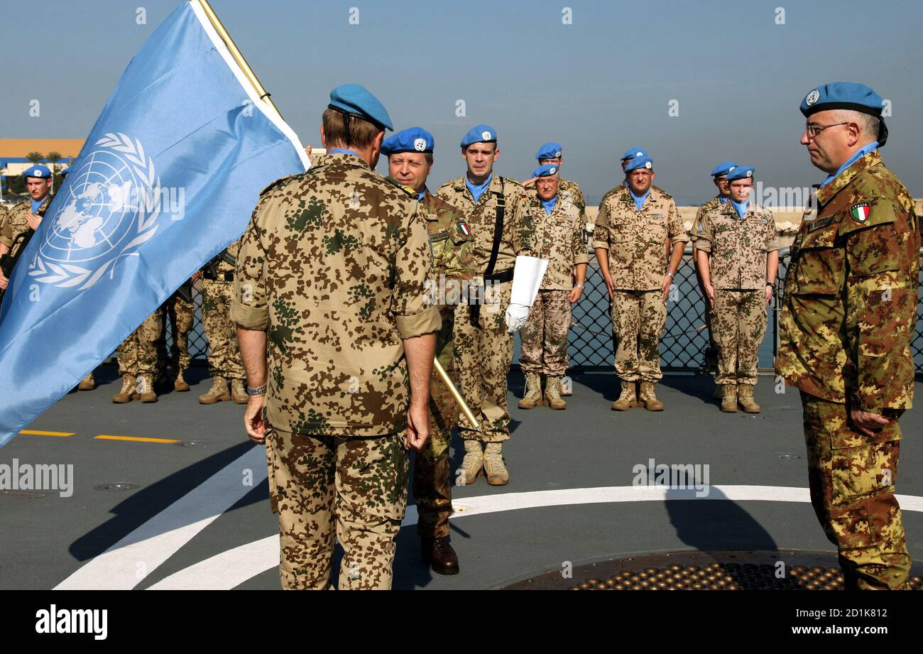 Incoming Maritime Task Force (MTF) commander Rear Admiral Paolo Sandalli of  Italy receives the United Nations flag from outgoing MTF commander  Germany?s Rear Admiral Juergen Mannhardt (L, back to camera) as United